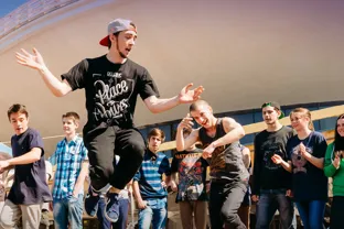 En grupp människor som står runt en man som dansar streetdance